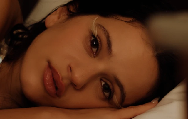 Rosalía con la cabeza recostada y mirada serena