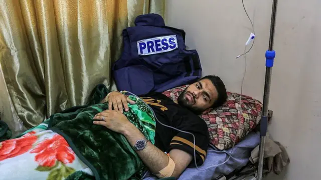 El fotoperiodista palestino Abdullah al-Attar en una camilla, tras ser herido en un ataque israelí en abril de 2025