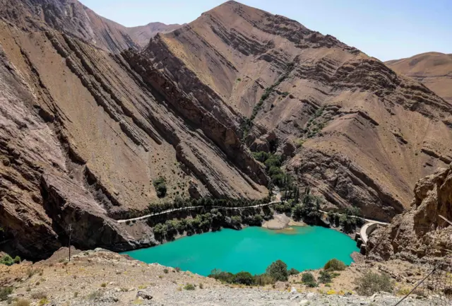 El agua azul brillante del embalse detrás de la presa Amir Kabir a lo largo del río Karaj en la cordillera de Alborz, en el norte de Irán, con altas montañas que lo rodean, el 1 de junio de 2025.