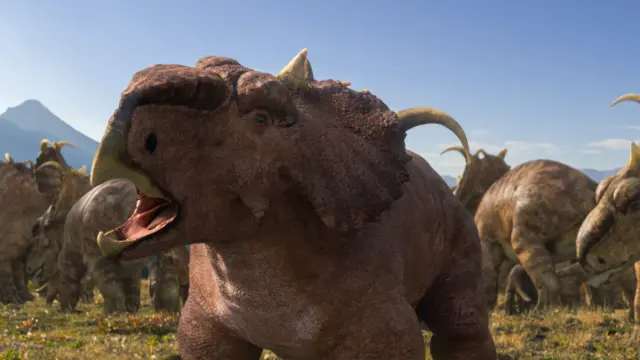 Imagen generada por ordenador que muestra un Pachyrhinosaur marrón con la boca afilada abierta, cuernos en la cabeza, con otros detrás comiendo vegetación.