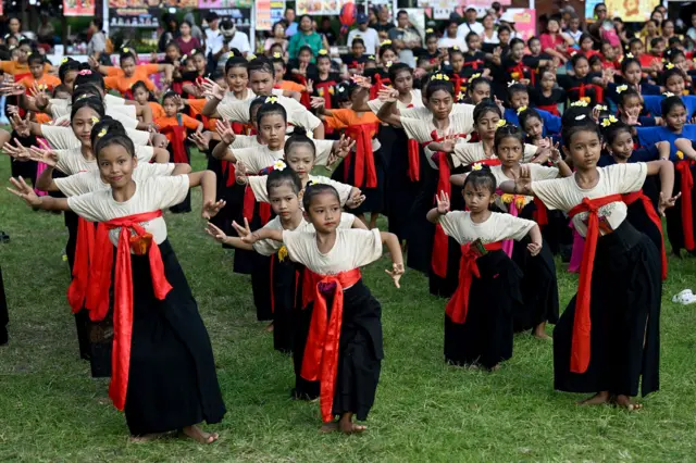 Unos niños interpretan una danza tradicional balinesa para despedir el sol de 2025 y dar la bienvenida al sol de 2026, durante una celebración de Nochevieja en Denpasar, en la isla turística indonesia de Bali, el 31 de diciembre de 2025.