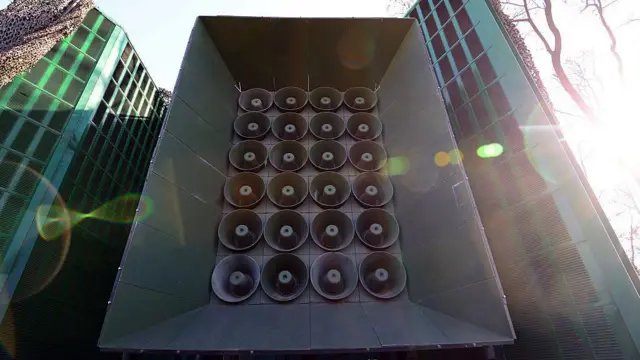 Un altavoz gigante camuflado entre el bosque en la frontera entre los dos países.