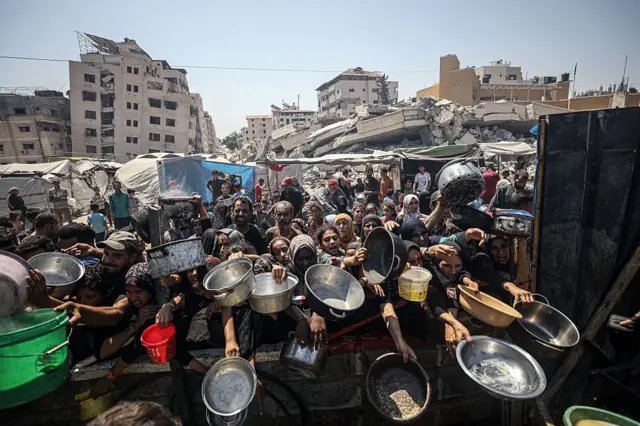 Un grupo de niñas y mujeres con sus platos a la espera de comida en Gaza