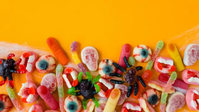 imagen de varias gominolas de distintos colores y sabores. Algunas tienen forma de gusanos, otras de calaveras, arañas y ojos. 