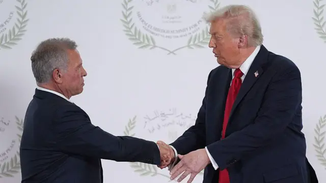 El rey Abdalá y Donald Trump se estrechan la mano en una cumbre de paz en Sharm el Sheij, Egipto. Ambos visten trajes oscuros.