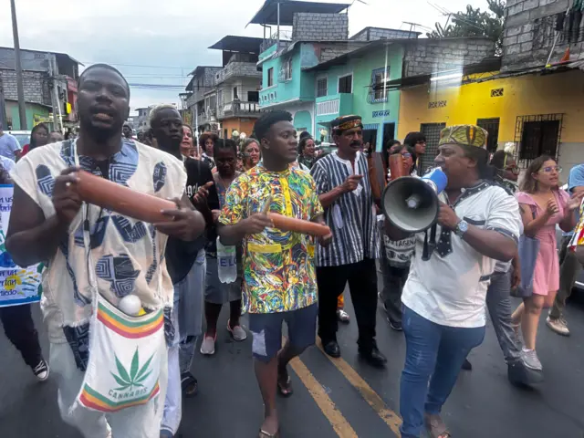 Varias personas en una manifestación con instrumentos musicales.