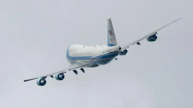 Un avión se inclina contra un cielo gris.