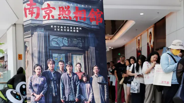 Espectadores hacen cola junto al cartel promocional de la película