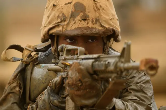 Mujer soldado de EE.UU. apunta con un fusil