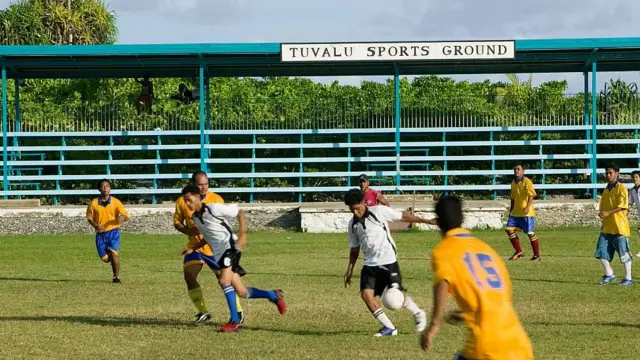 Jóvenes jugando al fútbol en un campo deportivo en Tuvalu