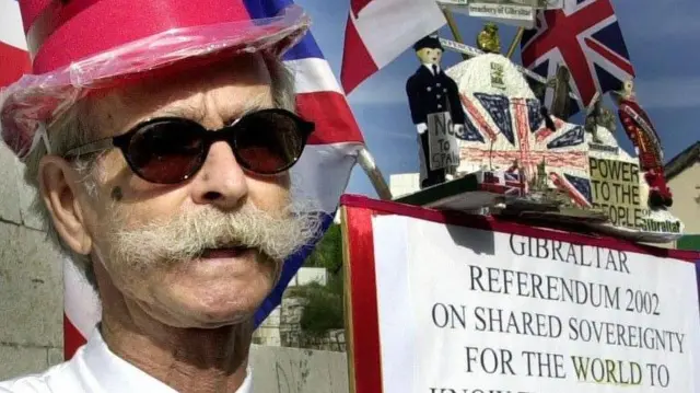 Un gibraltareño británico sostiene un cartel exhortando a votar