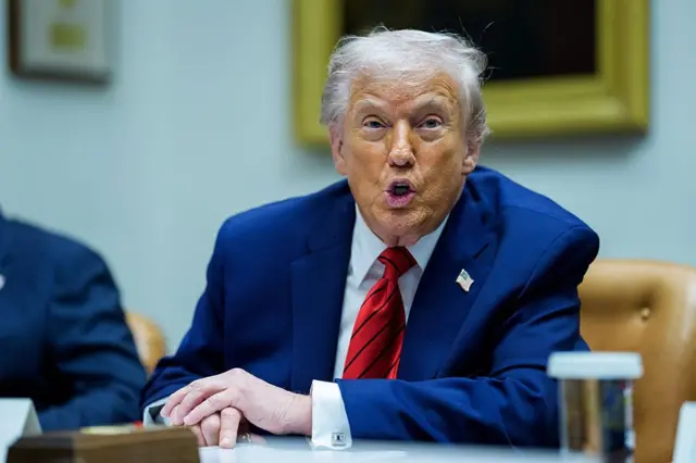 Donald Trump habla ante la prensa sentado en un salón de la Casa Blanca