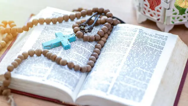 Una biblia con un rosario.