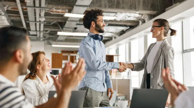 varias personas conversan en una oficina 