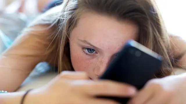 Una niña con un celular. 