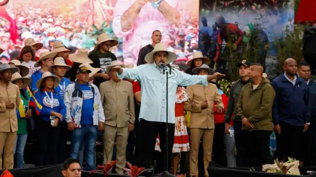 Maduro, con sombrero de paja, se dirige a la audiencia congregada en un auditorio. 
