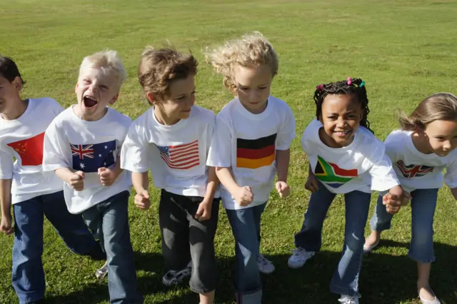 Niños con camisetas con banderas de diferentes países, incluyendo EE.UU.