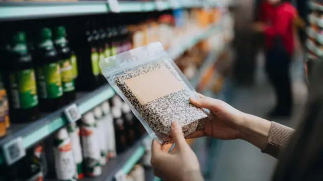 Una persona sostiene un producto etiquetado como natural en un supermercado