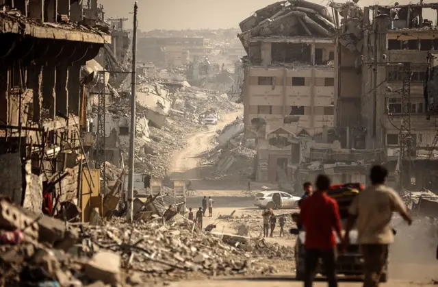 Palestinos caminan cerca de una zona donde militantes de Hamás y miembros del Comité Internacional de la Cruz Roja (CICR) buscan los cuerpos de rehenes israelíes entre los escombros de la ciudad de Gaza, el 5 de noviembre.