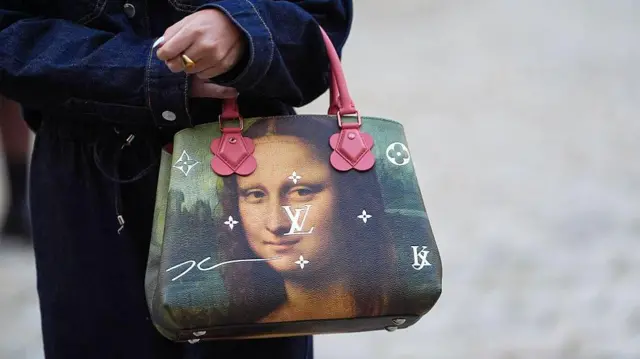 Mujer con una cartera con el retrato de la Mona Lisa