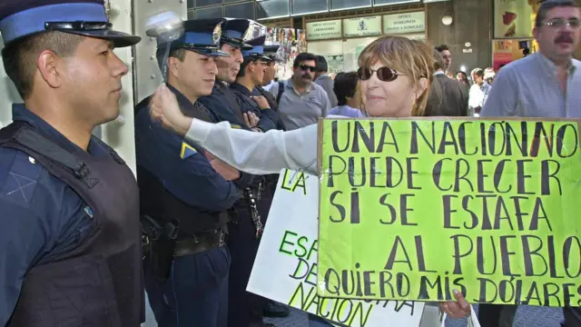 Una mujer sostiene un cartel que dice