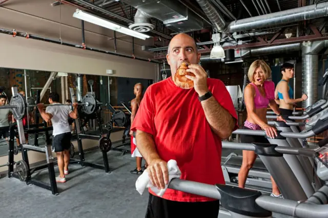 Hombre comiendo pastel en gimnasio