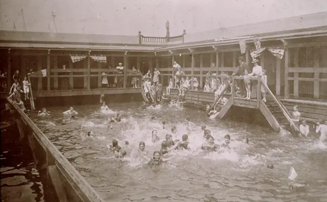 Niños nadando bajo la supervisión de adultos en el baño público N° 10 de la ciudad de Nueva York, circa 1897.
