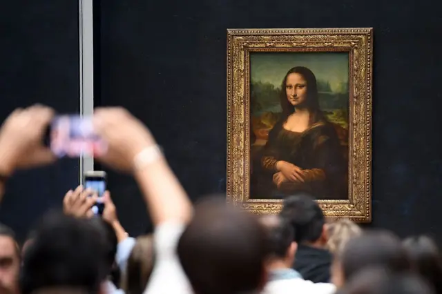 Asistentes del Museo del Louvre miran y toman fotos del cuadro de La Gioconda