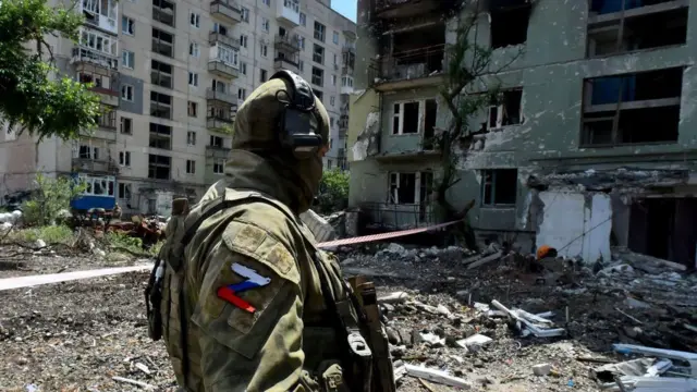 Un militar ruso patrulla una zona residencial destruida en la ciudad de Severodonetsk el 12 de julio de 2022, en medio de la acción militar rusa en Ucrania.