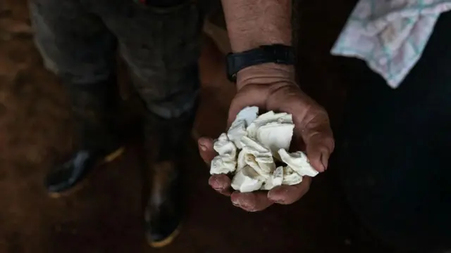 Individuo sostiene pasta de cocaína en el Cauca, Colombia.