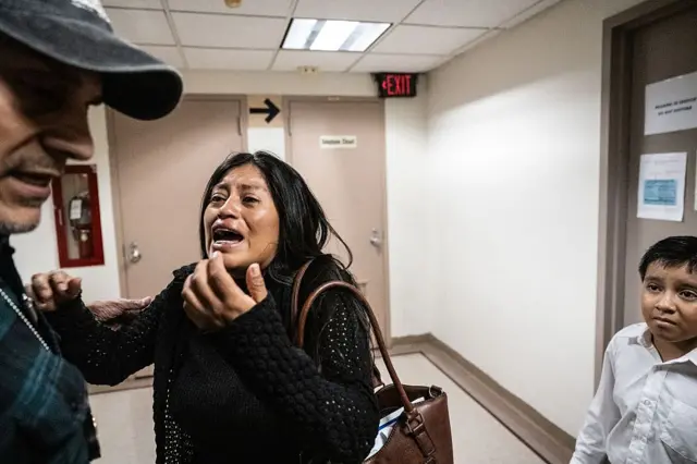 Mónica Moreta Galarza implora a un agente del ICE, con su hijo a la espalda, en los pasillos del tribunal de inmigración en el 26 Federal Plaza de Nueva York el 25 de septiembre de 2025. (Foto: Stephanie Keith/Getty Images)