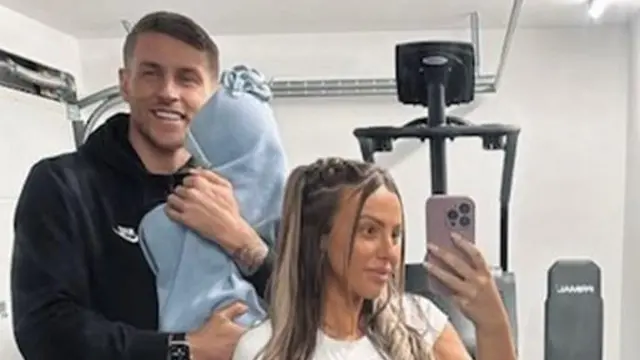 Holly, su marido y su bebé en el gimnasio.