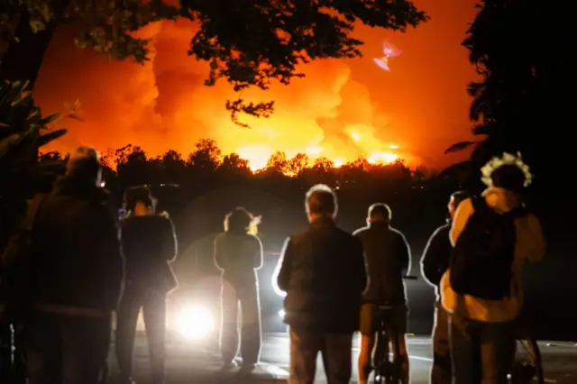 Personas observan un incendio en Los Ángeles