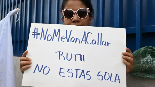 Una partidaria de la abogada de derechos humanos y jefa del departamento de anticorrupción de la ONG Cristosal, Ruth López, sostiene un cartel afuera del Centro Judicial Isidro Menéndez en San Salvador, el 4 de junio de 2025. (Foto de Marvin RECINOS / AFP) (Foto de MARVIN RECINOS/AFP a través de Getty Images)
