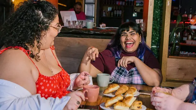 Tres amigas tomando café con croissants en una cafetería de Melbourne.
