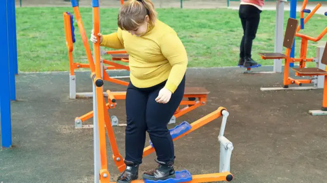  Niña con sobrepeso jugando al aire libre
