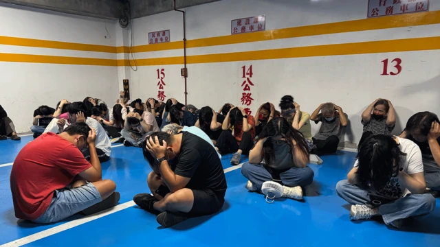 Personas en Kinmen con las manos sobre la cabeza sentadas en el suelo, como parte de uno de los simulacros.