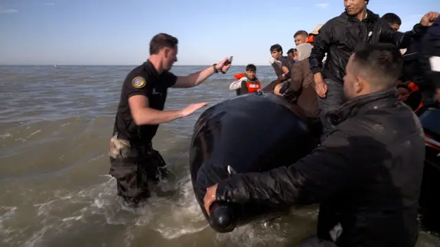 Un agente de la policía francesa agujerea varias veces el bote inflable con migrantes en el canal de la Mancha