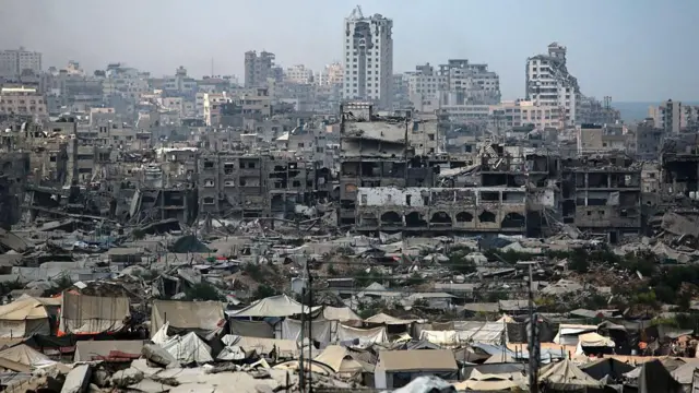 Una imagen de tiendas de campaña utilizadas como refugios temporales por palestinos desplazados se instalan cerca de edificios dañados por la guerra en la ciudad de Gaza.