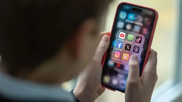 Un niño con un celular en su mano mira las aplicaciones. 