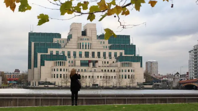 Una mujer fotografía el edificio del servicio de inteligencia británico situado en Londres.