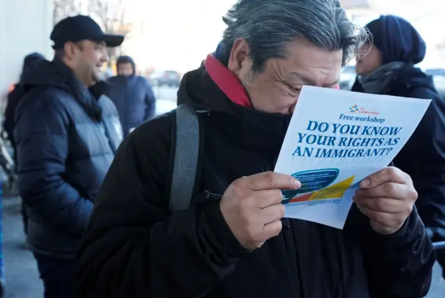 Un hombre lee un folleto de un taller gratuito titulado 