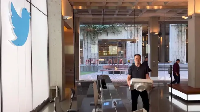 Elon Musk entra en la sede de X (Twitter) en San Francisco en 2022 cargando una pileta.