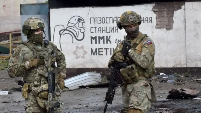 Militares rusos hacen guardia en la parte destruida de la Planta de Hierro y Acero Ilich en la ciudad portuaria ucraniana de Mariupol el 18 de mayo de 2022, en medio de la acción militar rusa en Ucrania. A principios de 2024, Putin planteó la idea de una terapia obligatoria para los soldados que regresaban, pero dicha política aún no se ha implementado.