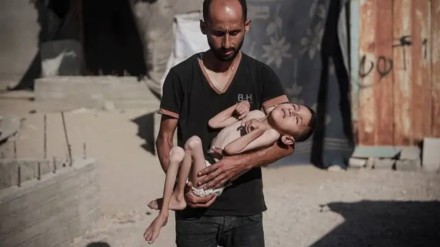 Malik, de 6 años, en brazos de su padre