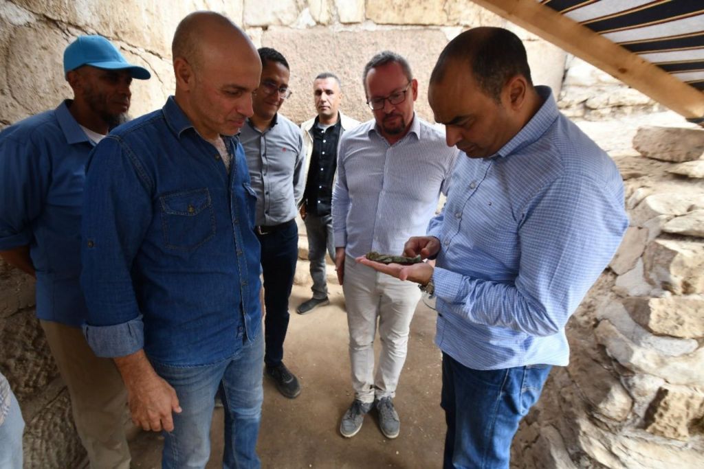 Uno de los responsables de la excavación sostiene una de las estatuillas funerarias encontradas en Tanis