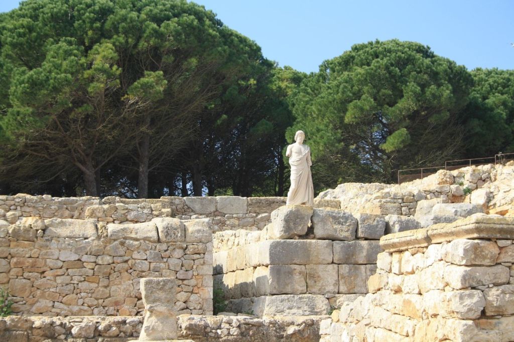 Muros de piedra y estatua en un yacimiento