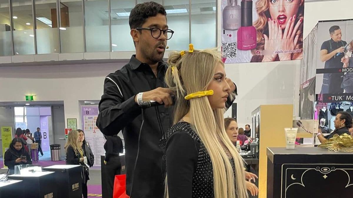 Estilista alaciando el cabello de una modelo en la Expo Beauty Show 2025.