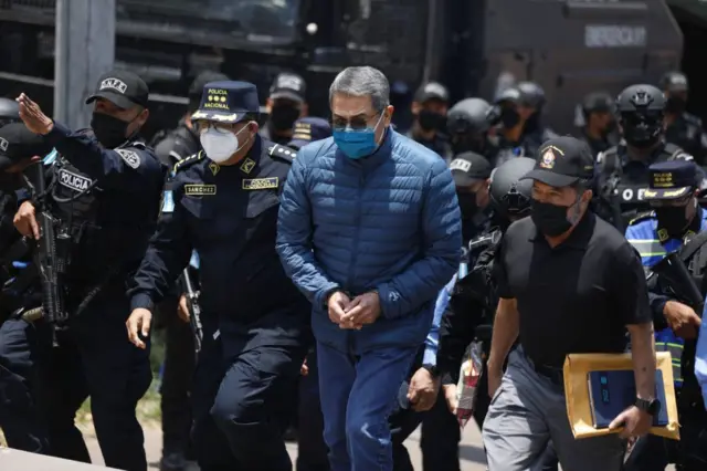 Oficiales de policía hondureños escoltan a Juan Orlando Hernández, ex presidente de Honduras, en el centro, al Aeropuerto Internacional de Toncontín (TGU) en Tegucigalpa, Honduras, el jueves 21 de abril de 2022. El tribunal supremo de Honduras ratificó la extradición del expresidente Hernández a Estados Unidos, donde enfrentará cargos por tráfico de drogas. Fotógrafo: Tomas Ayuso/Bloomberg vía Getty Images)