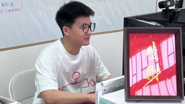 Feiyu, un joven de 30 años que es dueño de la empresa Pretend To Work Company, mira la pantalla de su computadora